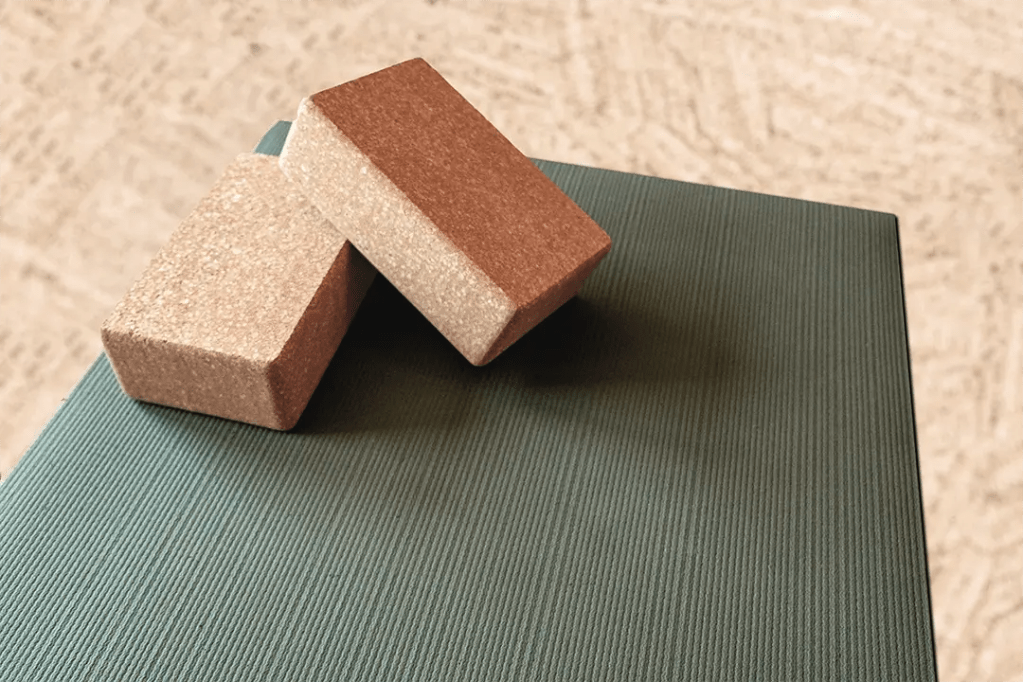 Briques de Pilates posées sur un tapis, accessoires essentiels pour le Pilates avec brique.